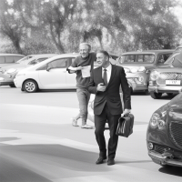 נערים יהודים עם חליפה ארוכה עם קבוצת שערות בצדדים וזקן יושבים ולומדים בספר קודש ליד שולחנות במקום אחד